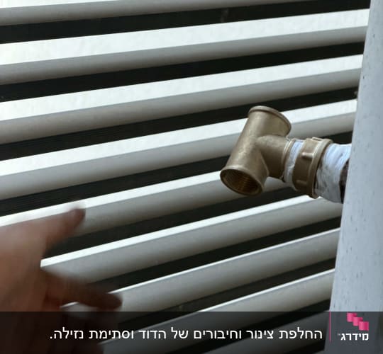 צינור מתכת עם ברז ליד יד